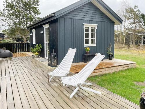 two chairs on a deck with a tiny house at Cozy Summer House Close To Bisnap Beach in Hals