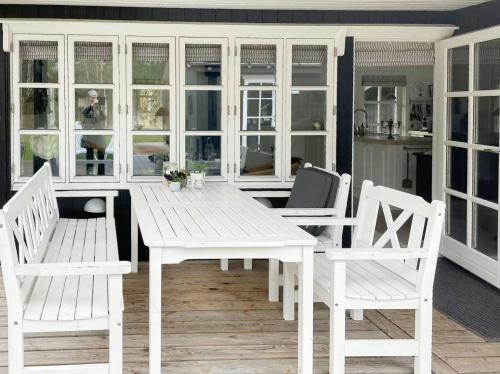 a white table and chairs on a porch at Cozy Summer House Close To Bisnap Beach in Hals