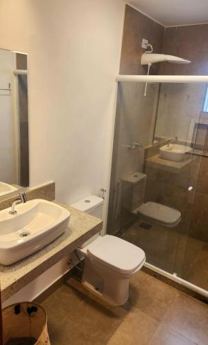 a bathroom with a sink and a toilet and a shower at Pousada Noa in Cabo Frio