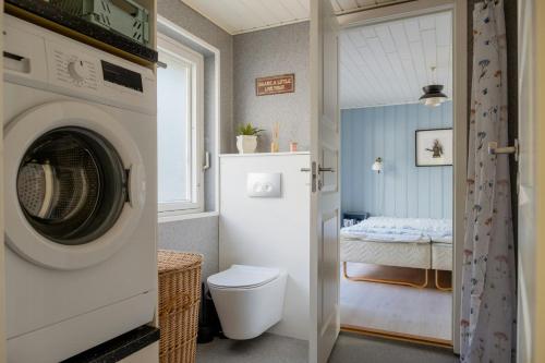 a bathroom with a washer and dryer next to a bedroom at Magical Atmosphere Close To The Sea in Sæby