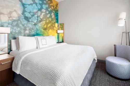a hotel room with a bed and a chair at Courtyard Bowling Green Convention Center in Bowling Green
