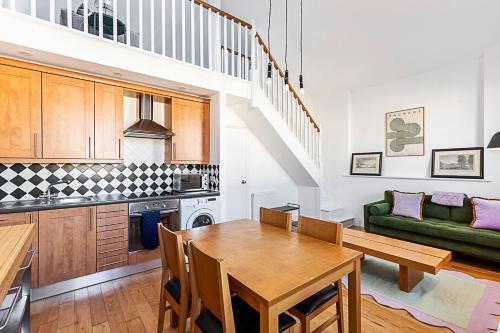 a kitchen and dining room with a table and a couch at Stylish Chelsea Flat with Luxe Comfort & Charm in London