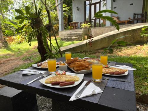 een zwarte picknicktafel met schalen vol eten en drinken bij ORENDA ECO LODGE & SPA in Galle
