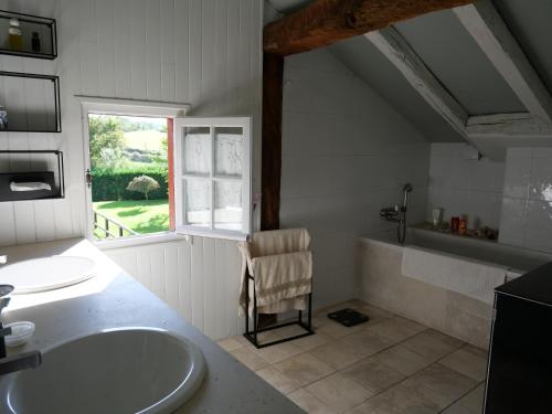 une salle de bain avec une baignoire, un lavabo et une fenêtre dans l'établissement Maison de caractère au calme et vues magnifiques, à Sare