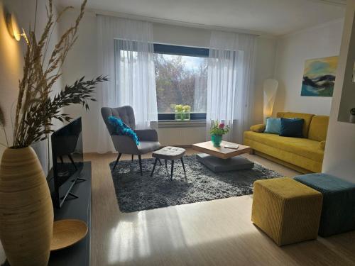 a living room with a yellow couch and a table at Quartier 2 in Fulda