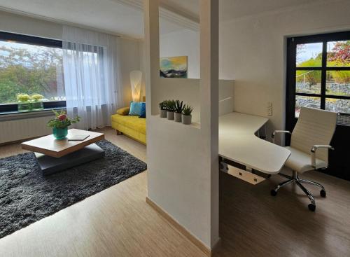 a living room with a chair and a desk and a couch at Quartier 2 in Fulda