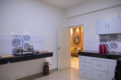 a kitchen with white cabinets and a black counter top at Casa Nova - 3BHK - Gachhibowli in Kondapur