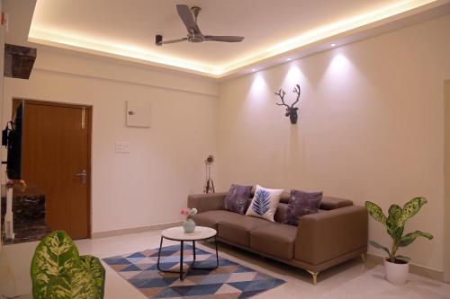 a living room with a couch and a ceiling fan at Casa Nova - 3BHK - Gachhibowli in Kondapur