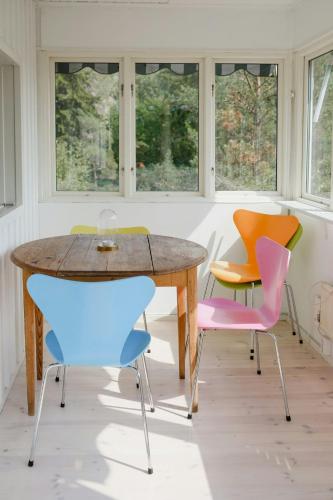 a table and four chairs in a room with windows at Idyllic Holiday Home With Scenic Views On Älgö in Saltsjöbaden