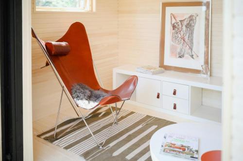 a orange chair in a room with a table at Idyllic Holiday Home With Scenic Views On Älgö in Saltsjöbaden