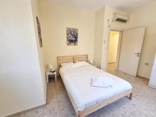 a bedroom with a large bed with white sheets at A villa in the desert in Midreshet Ben Gurion