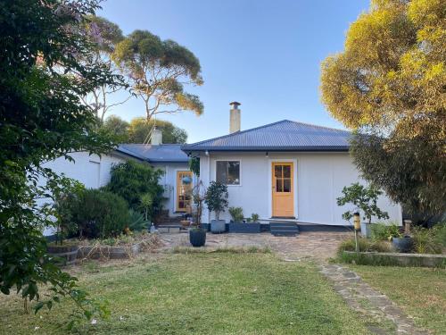 a white house with a yard at WattleJack Cottage in Kingscote