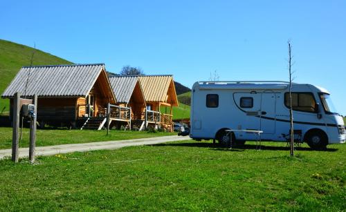 a blue van parked in front of some wooden houses at Camping IZARPE in Aróstegui