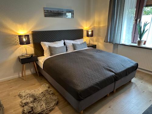 a bedroom with a bed with two lamps and a rug at Ferienwohnung Norderstedt in Norderstedt
