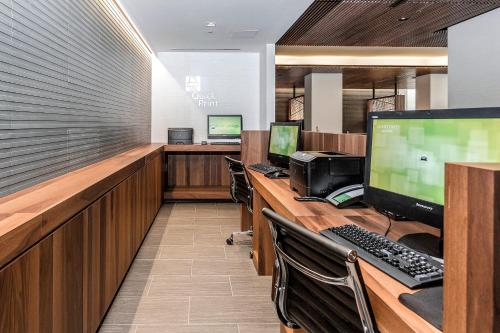 an office cubicle with three computer monitors and a desk at Courtyard by Marriott Long Island City/New York Manhattan View in Queens