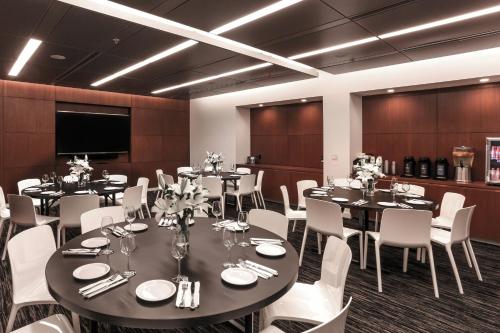 a conference room with tables and white chairs at Courtyard by Marriott Long Island City/New York Manhattan View in Queens