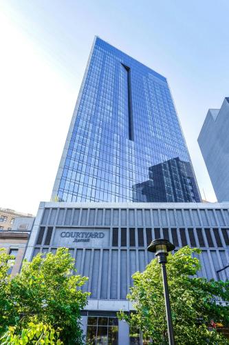 a tall building with a sign on the side of it at Courtyard by Marriott Long Island City/New York Manhattan View in Queens