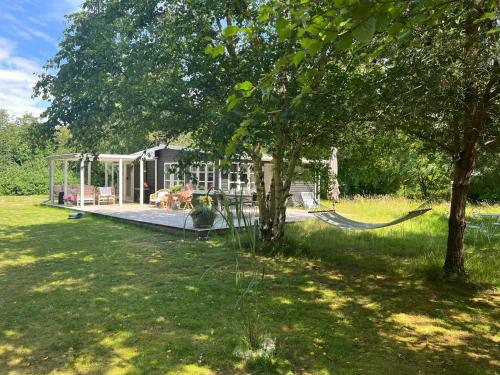 une maison avec un hamac dans une cour dans l'établissement Cottage Near Beach Perfect For Families, à Højby
