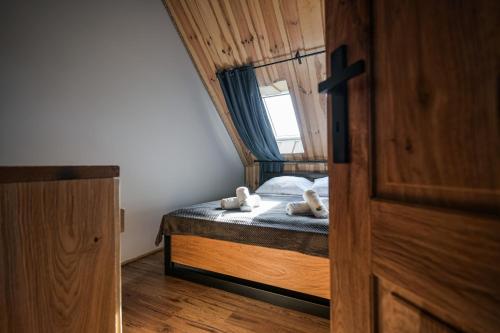 a bedroom with a bed with two teddy bears on it at Dadajowa Osada - Dadaj in Biskupiec