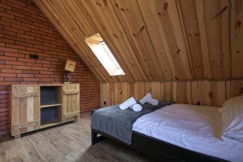 a bedroom with a bed in a wooden room at Dadajowa Osada - Dadaj in Biskupiec