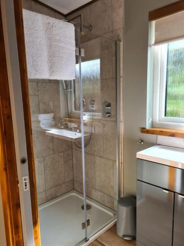 a shower with a glass door in a bathroom at The Hide in Ullapool