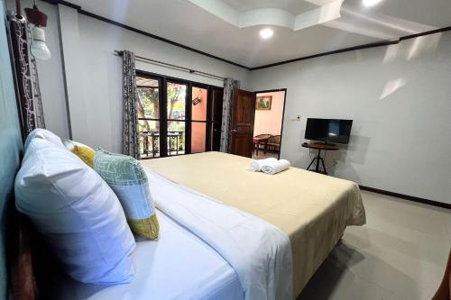 a bedroom with a bed and a tv in a room at Saithong Resort in Udon Thani