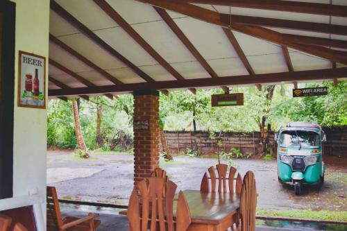 an old car parked in a yard with a table and chairs at Green Cottage in Anuradhapura