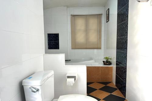 a white bathroom with a toilet and a sink at Saithong Resort in Udon Thani