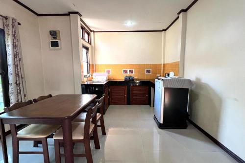 a small kitchen with a table and a refrigerator at Saithong Resort in Udon Thani