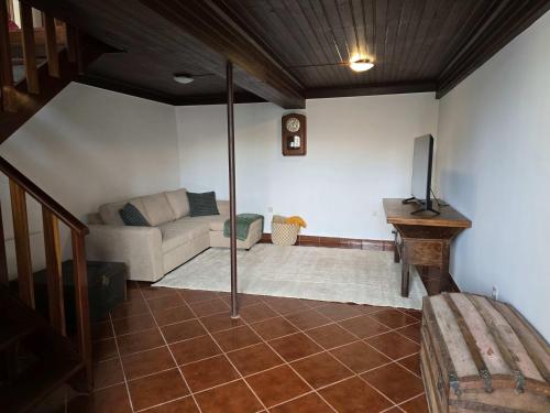 a living room with a couch and a television at GuestReady - Countryside atmosphere in Sernancelhe in Fonte Arcada