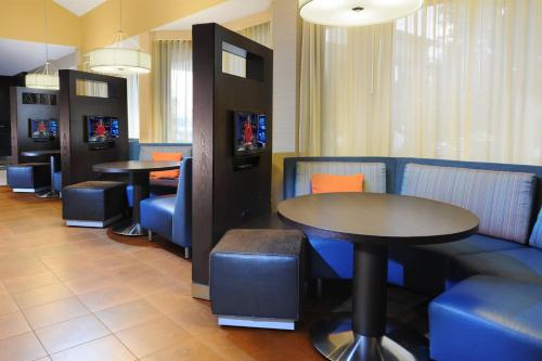 a restaurant with two tables and blue chairs at Courtyard by Marriott Houston Hobby Airport in Houston