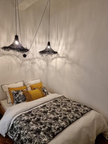 une chambre avec deux lustres au-dessus d'un lit dans l'établissement Appartement Cosy Hyper Centre Climatisé - Rue Bédarrides, à Aix-en-Provence