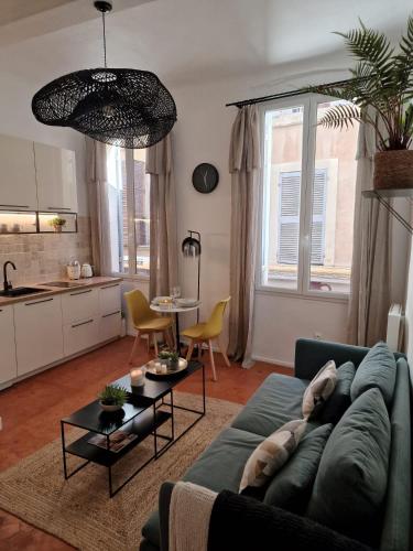 un salon avec un canapé bleu et une cuisine dans l'établissement Appartement Cosy Hyper Centre Climatisé - Rue Bédarrides, à Aix-en-Provence