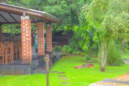 a garden with a brick pavilion and a lawn at Green Cottage in Anuradhapura