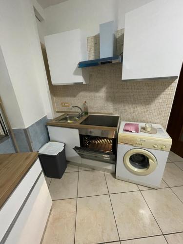 een keuken met een wasmachine en een wastafel bij Sweet Stabia Dream in Castellammare di Stabia