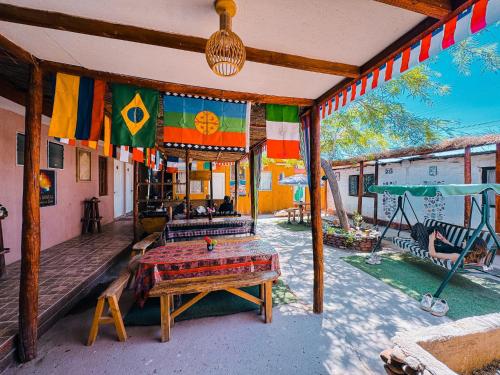 a patio with a table and flags on a house at CASA HOSTAL LA PASKANA ATACAMEÑa in San Pedro de Atacama