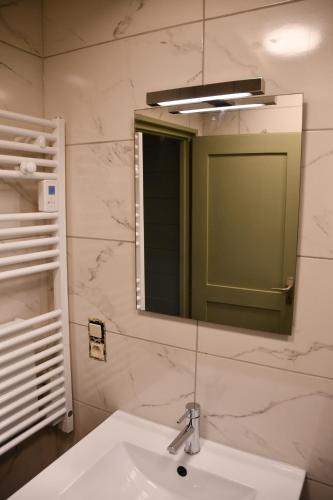 un baño con lavabo y espejo en ArdenParks PetiteSuisse Chalet Renardeau, en Manhay