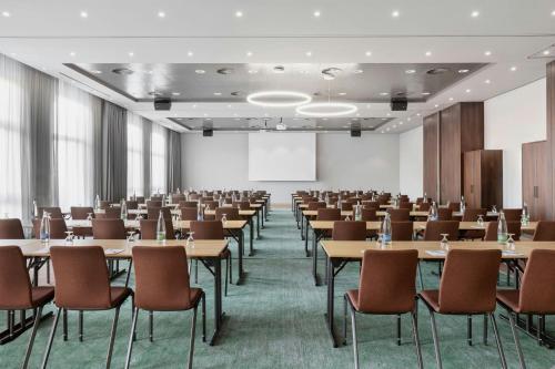 a large room with tables and chairs and a podium at Courtyard by Marriott Basel in Pratteln
