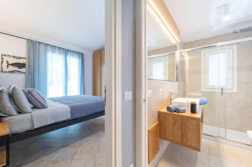a bedroom with a bed and a bathroom with a window at Elbitat Homes in Bagnaia