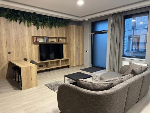 a living room with a couch and a television at NOMAD APARTMENTS in Mažeikiai