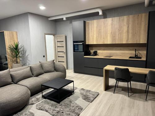 a living room with a couch and a kitchen at NOMAD APARTMENTS in Mažeikiai