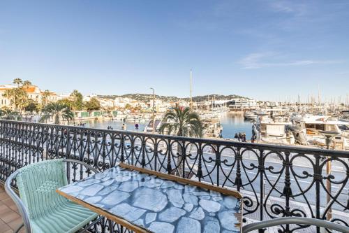un balcon avec une table et des chaises et un port de plaisance dans l'établissement L'HONORAT vue mer et port, à côté des plages du Midi et proche du Palais, à Cannes
