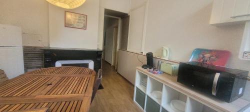 Cette chambre comprend une cuisine avec une table et une télévision. dans l'établissement Coeur de ville, à Béziers