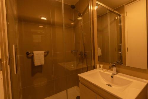 a bathroom with a sink and a shower with a glass door at Studio 56 by Terrado in Antofagasta