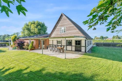 a house with a patio and a lawn at Dejligt landhus med 2 værelser in Toreby