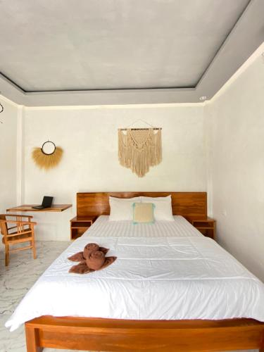 a teddy bear sitting on a bed in a bedroom at Sumbul View Surfcamp in Airsatang