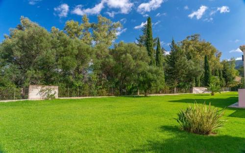 a park with green grass and trees in the background at Sami Beach Villas Fedra in Sami
