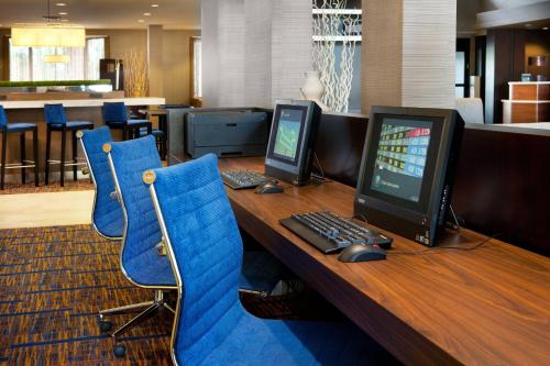 an office with a desk with a computer and blue chairs at Courtyard by Marriott Oakland Airport in Oakland
