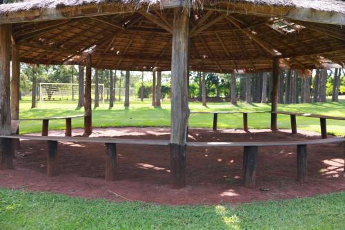 a wooden bench under a pavilion in a park at Hotel Berro D`Agua Eco Resort in Avaré