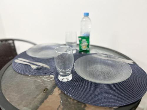 a table with plates and a bottle and a glass at I-17 um Studio aconchegante in Maceió